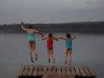 Kinder springen vom Steg in den See